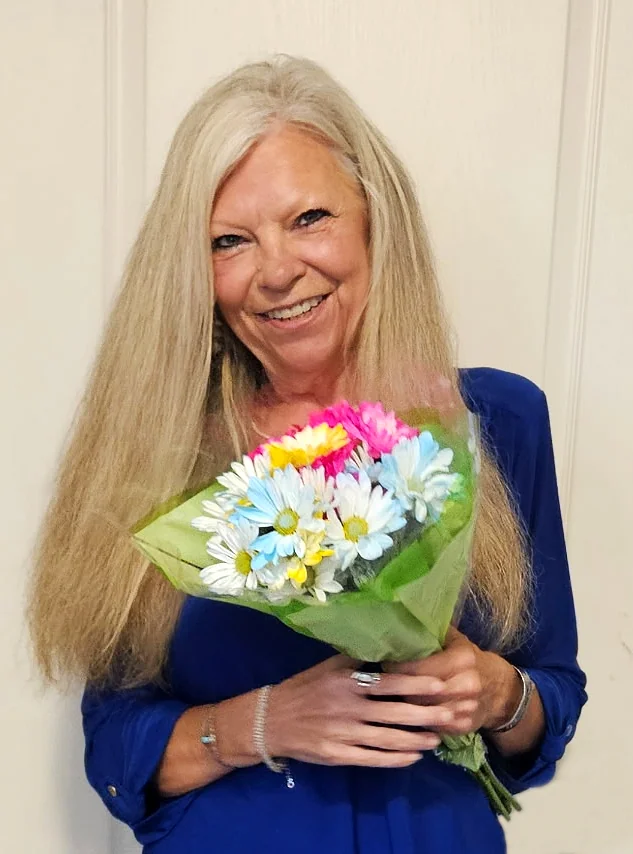 Photo of Fire Mountain Candles team member holding a colorful bouquet of flowers.